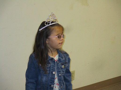 A child is wearing a crown at the BSS Christmas Party